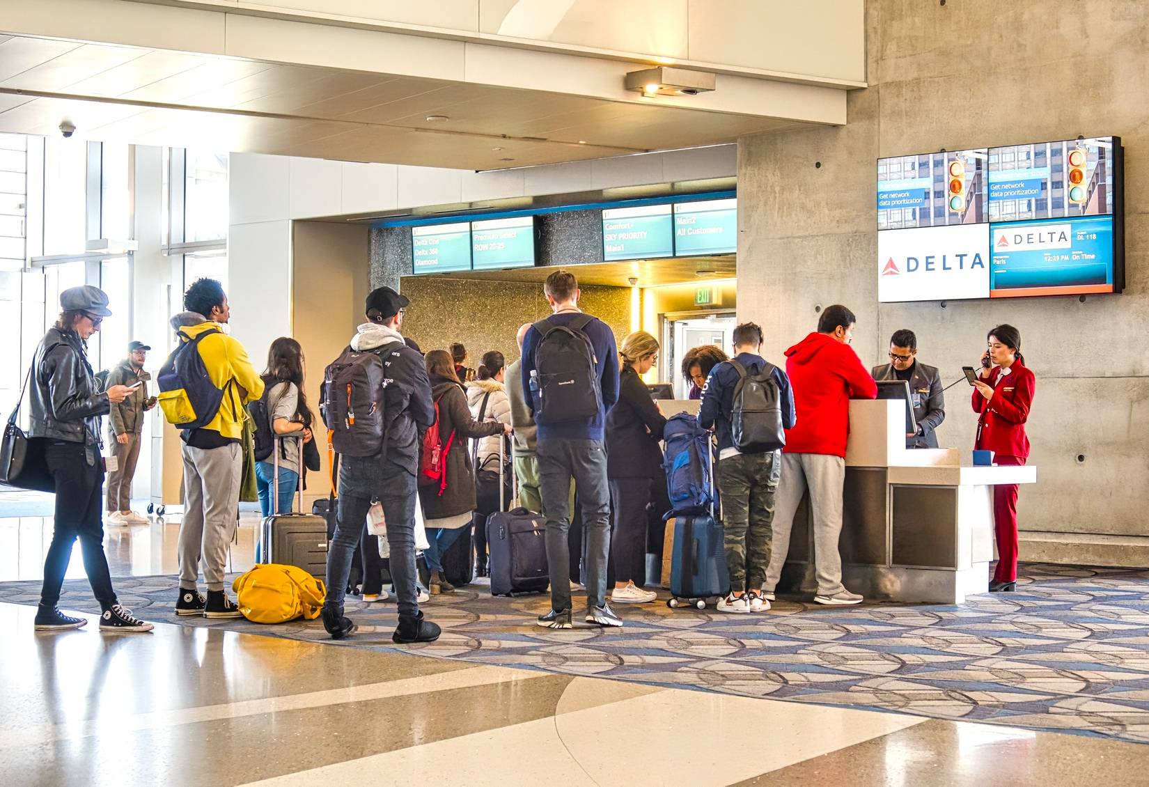  Passengers standing in line at a Delta Air Lines boarding gate counter