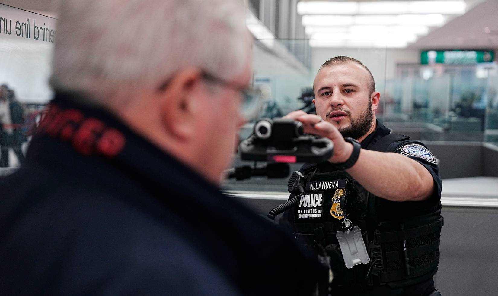 U.S. Customs and Border Protection (CBP) officer using facial scanning on a traveler at a U.S. airport