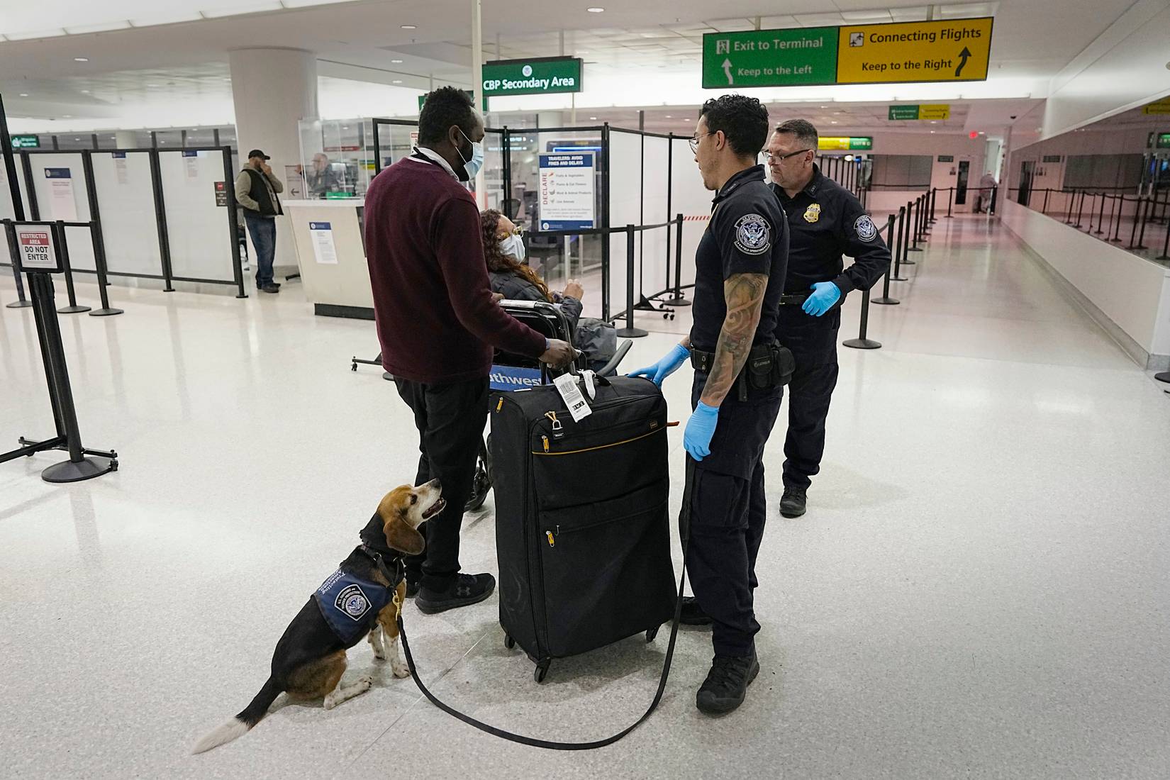 U.S. Customs and Border Protection (CBP) officers speaking with a passenger at a U.S. airport