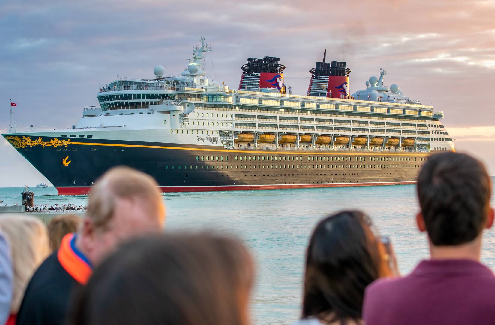 Disney Cruise Ship sailing at sunset in front of Mallory Square
