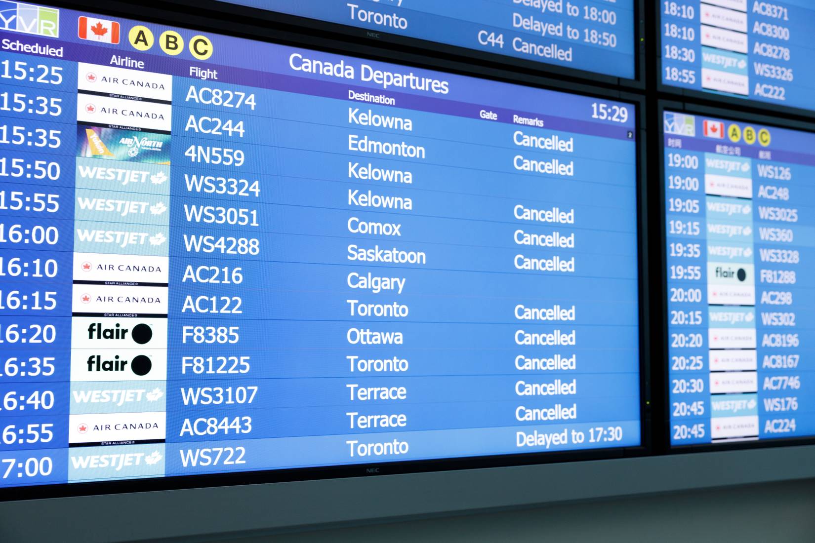 Flight information display at Vancouver airport showing numerous cancelled flights from Air Canada, WestJet and Flair Airlines