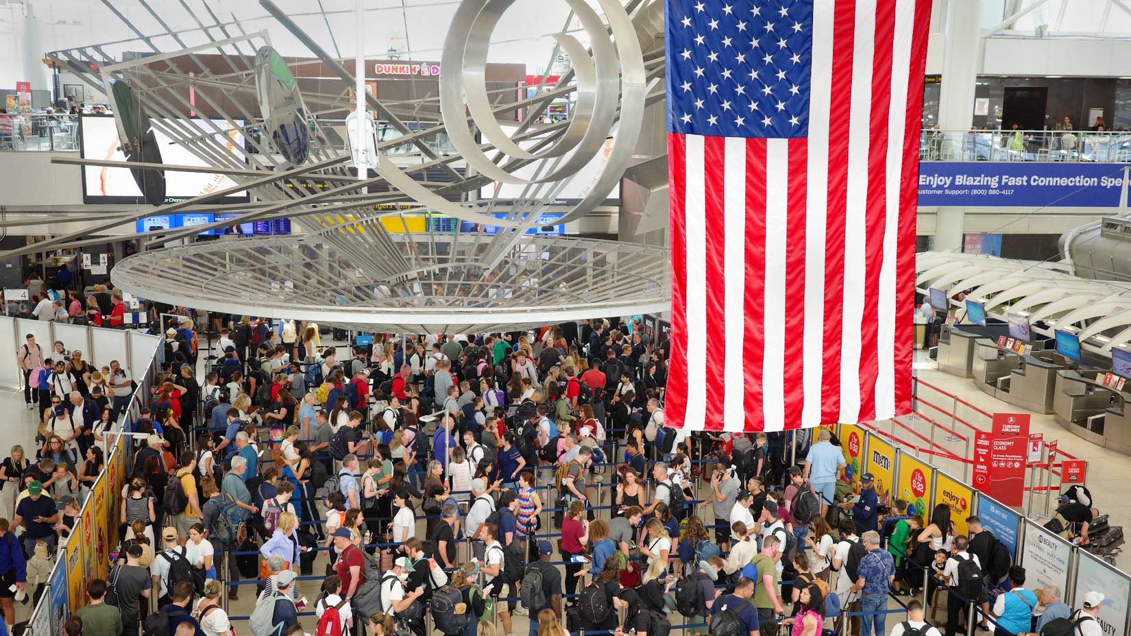 Travelers jam a security checkpoint at John F. Kennedy International Airport (JFK) in New York on the eve of the July 4th holiday.