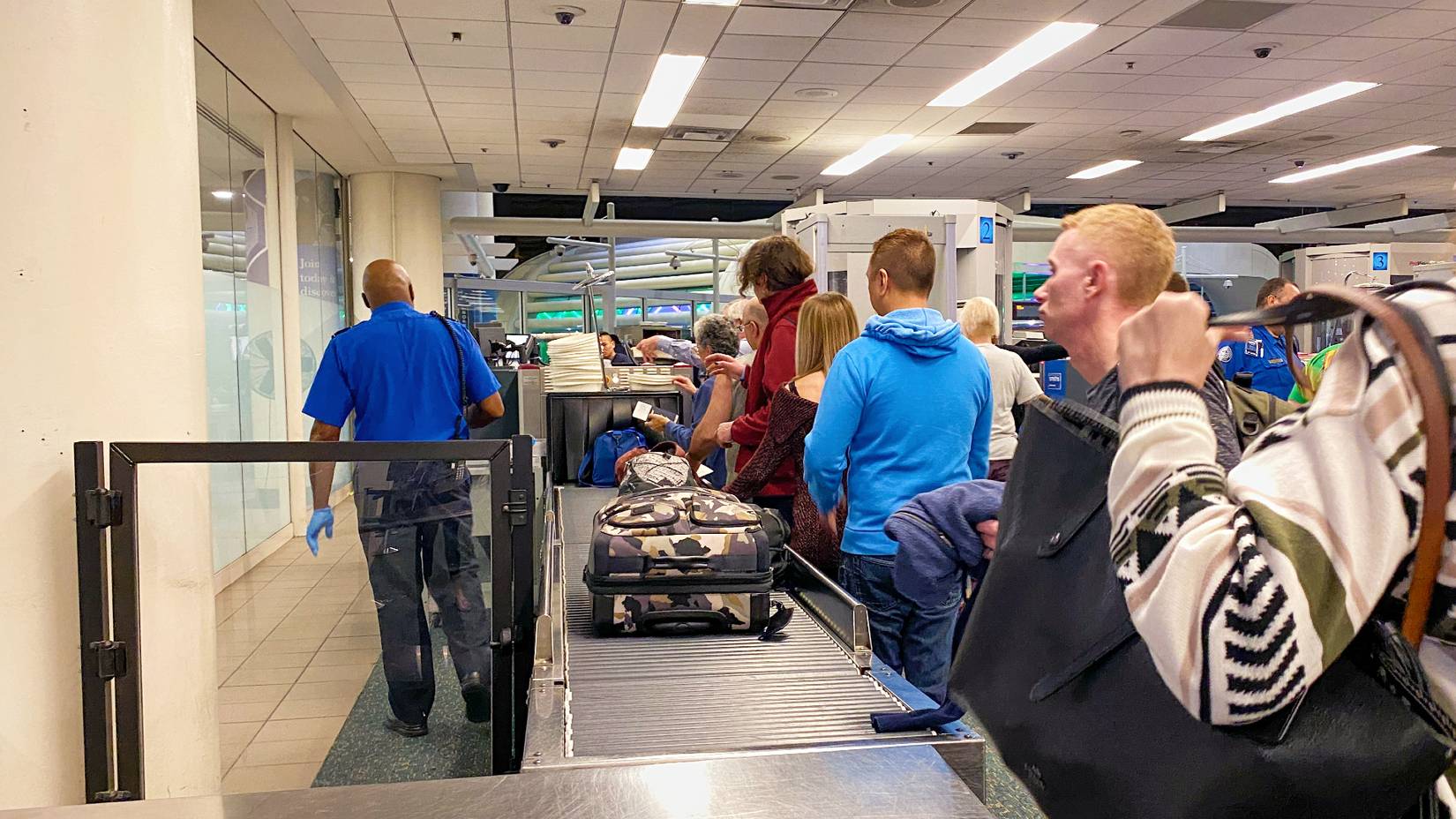 People waiting in line to go through TSA screening at Orlando International Airport (MCO) on a busy day.
