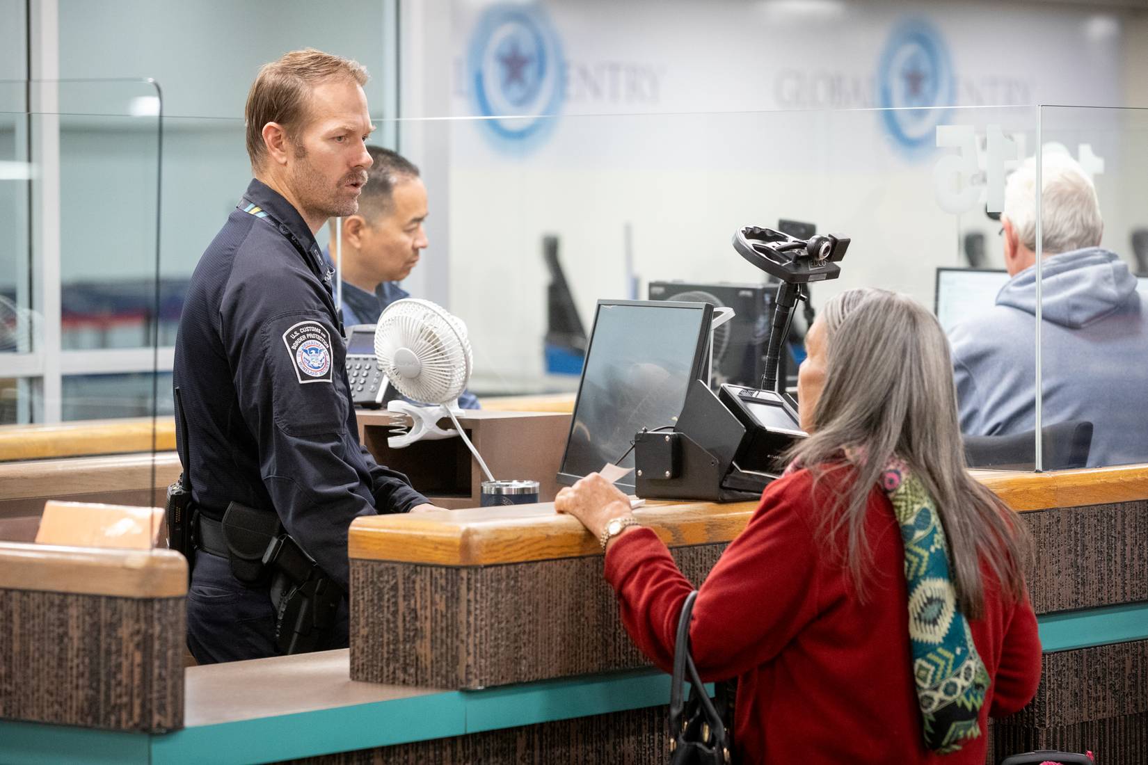 U.S. Customs and Border Protection (CBP) officer processing arriving international travelers at a port of entry