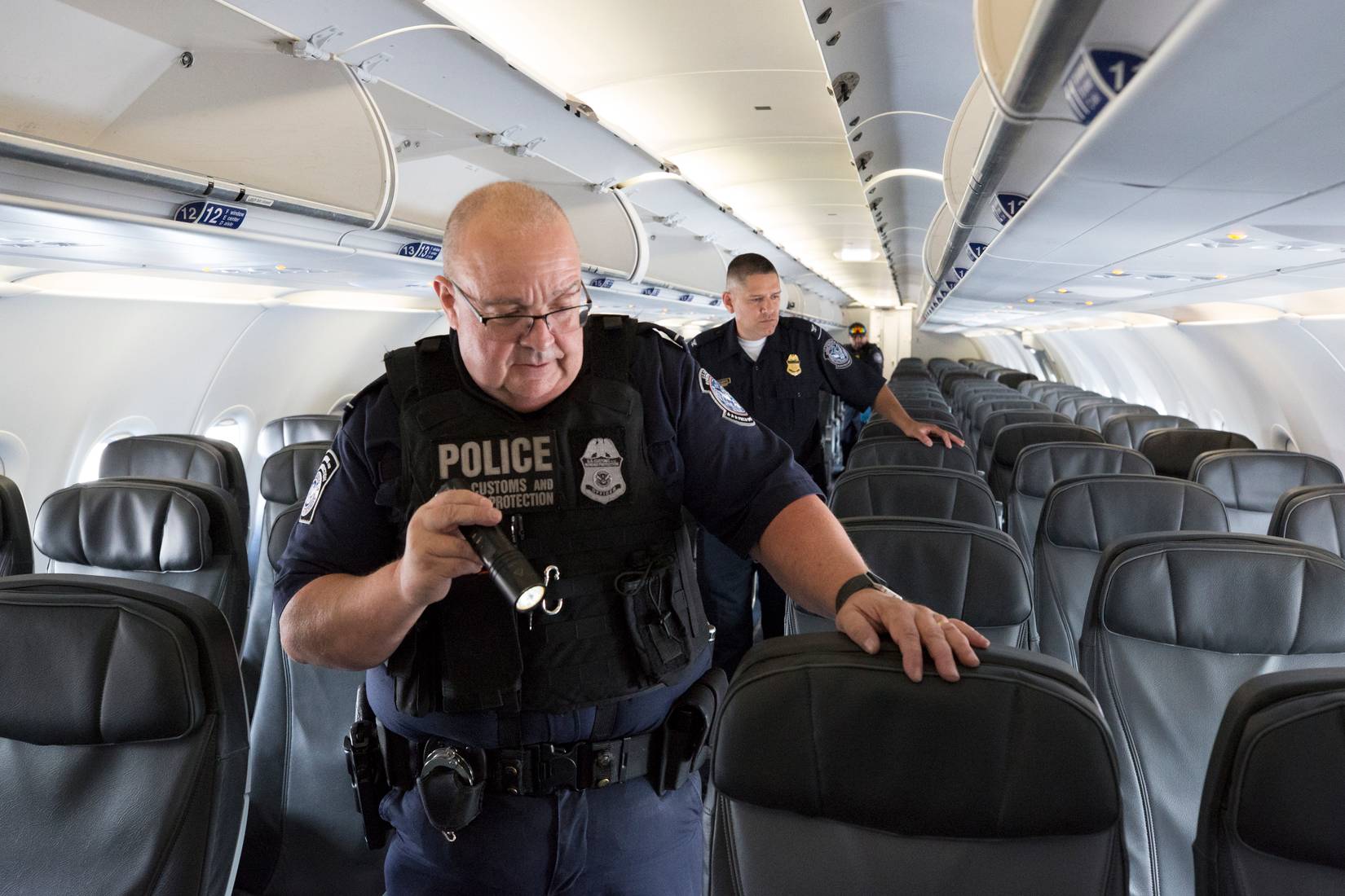U.S. Customs and Border Protection (CBP) officers searching an aircraft at an American airport