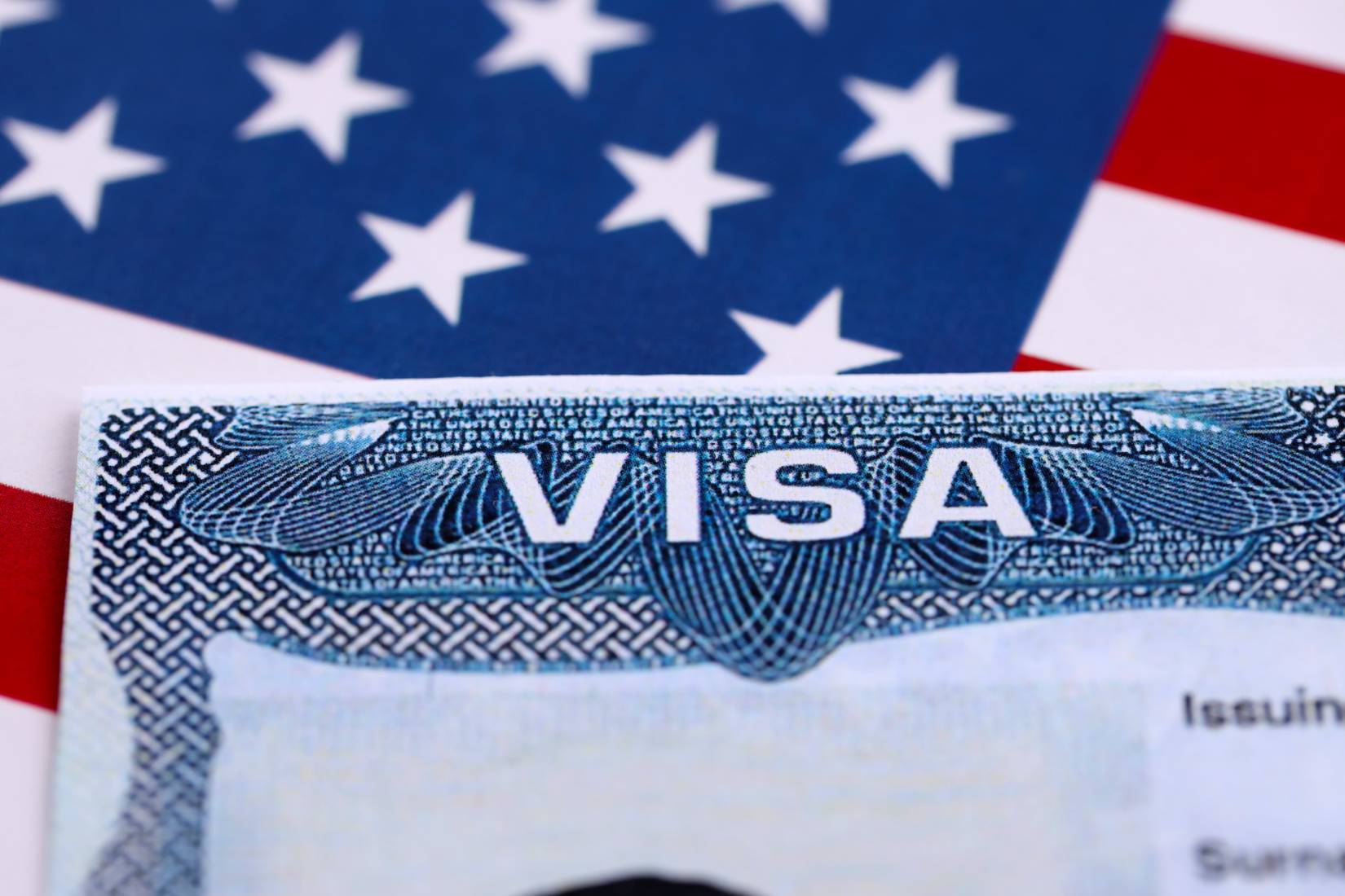 A United States passport with a visa inside. U.S. flag in the background