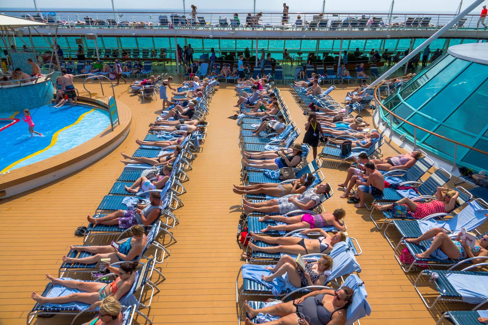 Royal Caribbean Rhapsody of the Seas guests on sun loungers by the deck pool