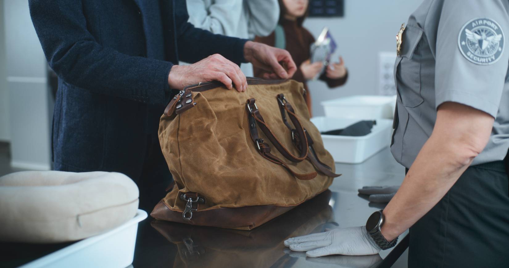 Security Officer Checking Bag During TSA Screening Procedures