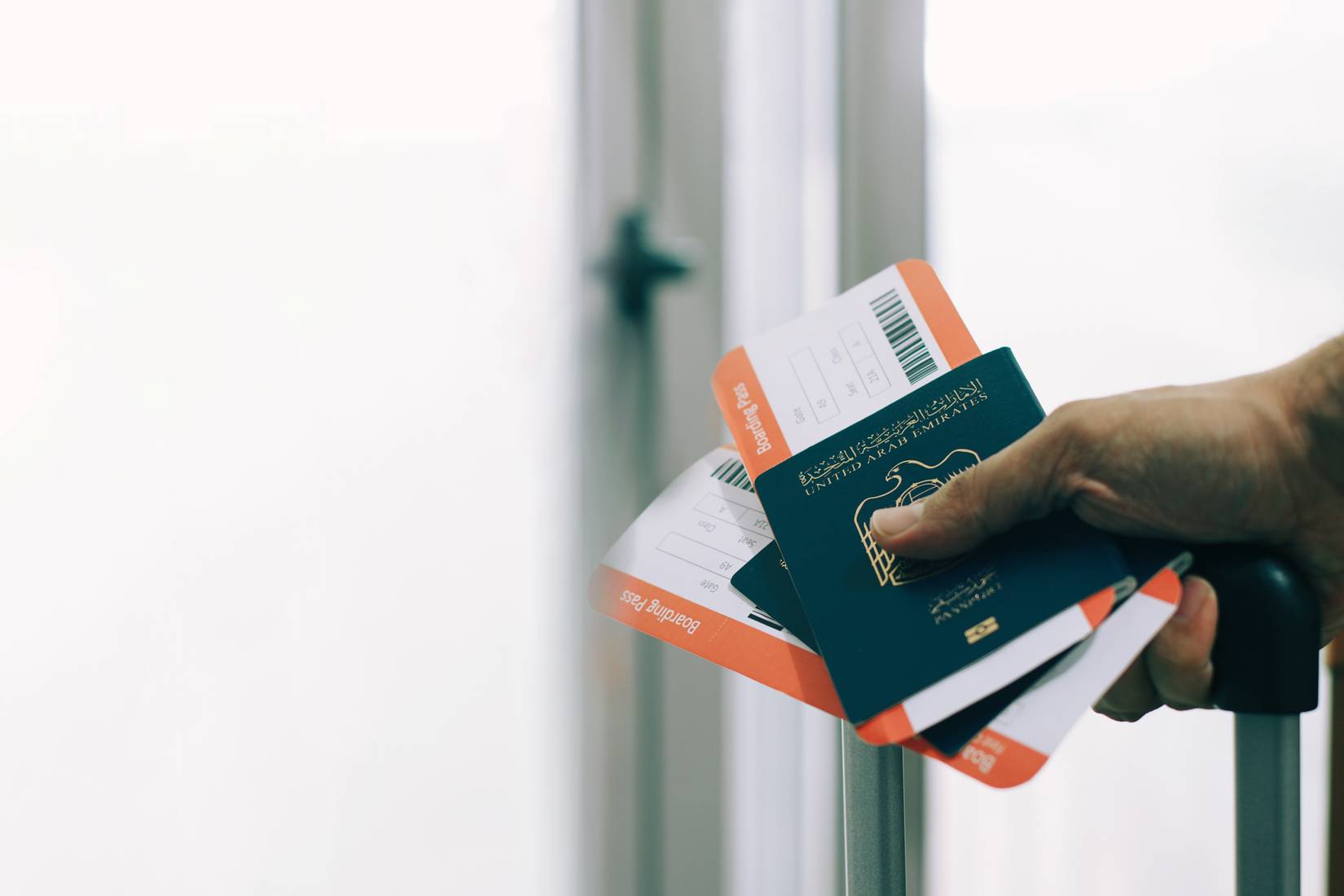 passenger holding UAE passports and airline tickets in airport