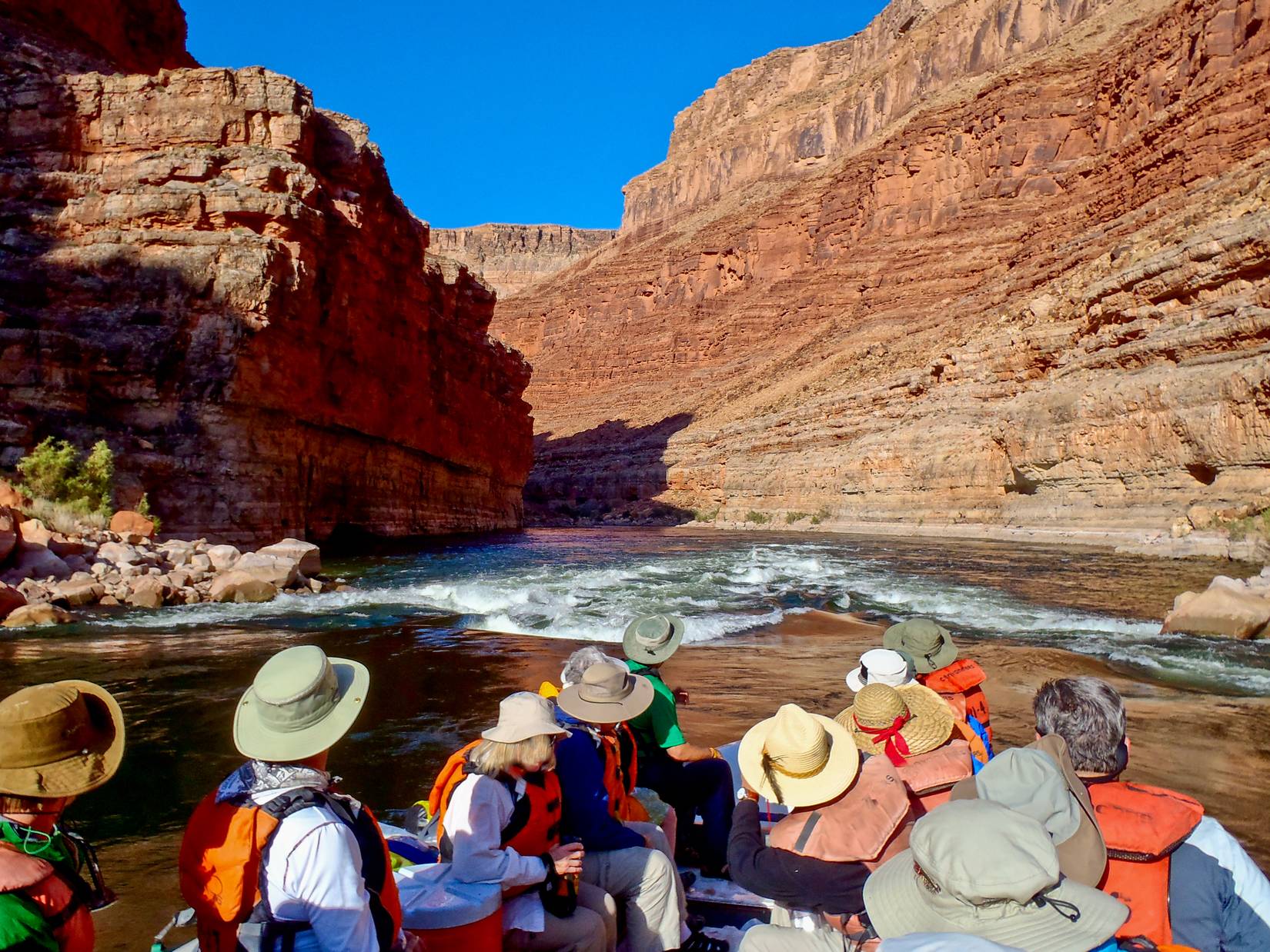 River rafters approach a rapid on the Colorado River in the Grand Canyon in Arizona on a sunny spring afternoon