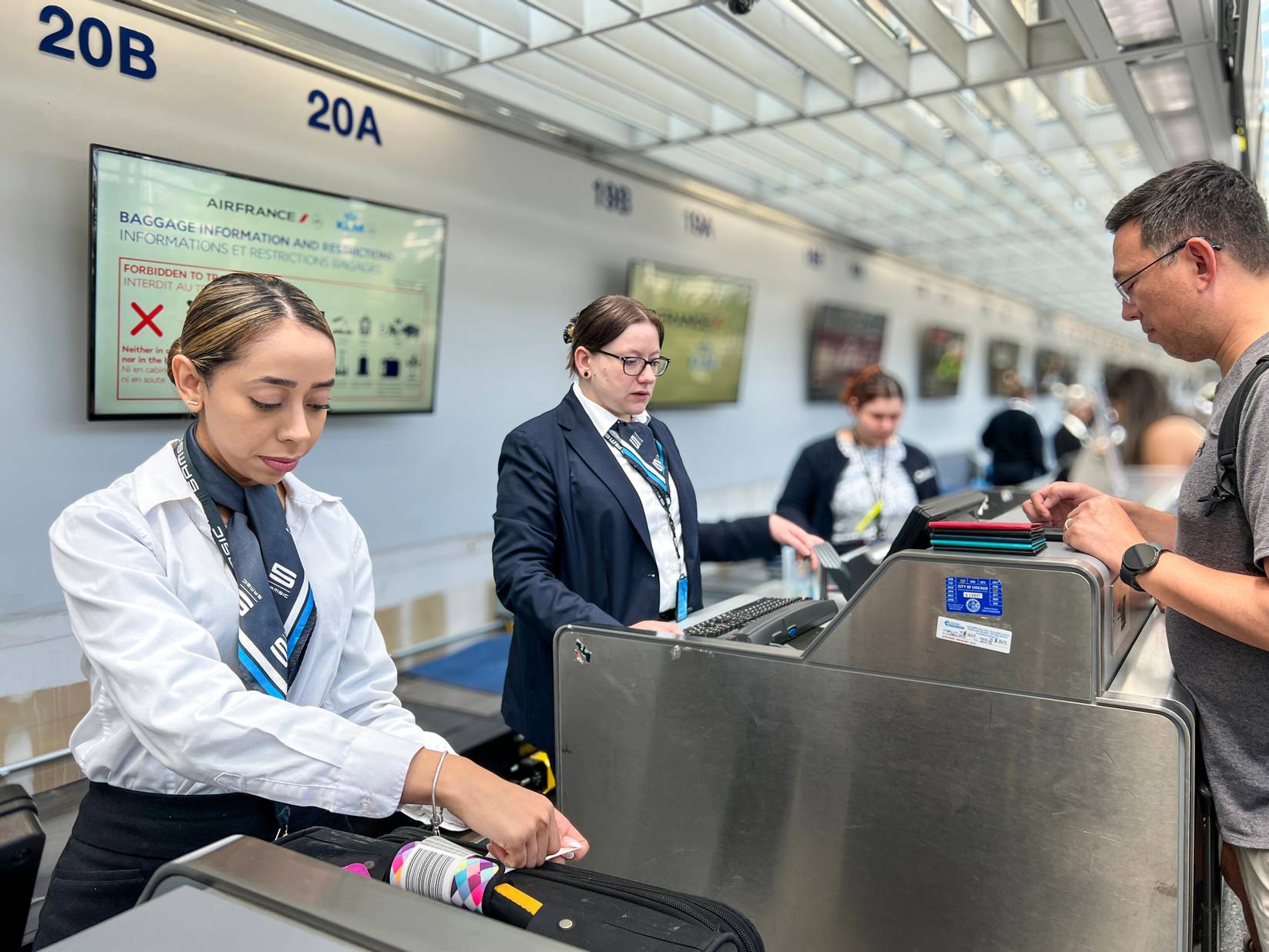 An airline employee checks in luggage for the passenger at Chicago O'Hare International Airport.
