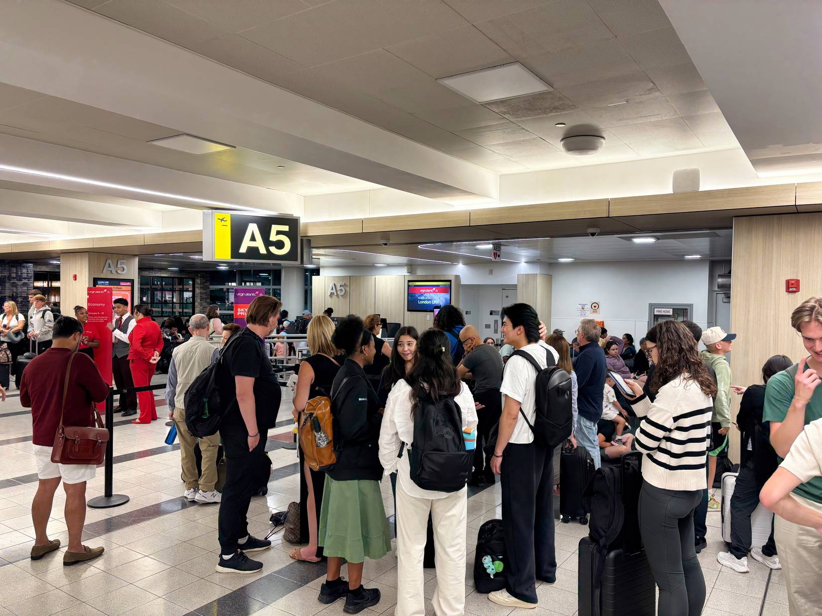 Travelers line up to board a flight at New York City's John F Kennedy Airport.