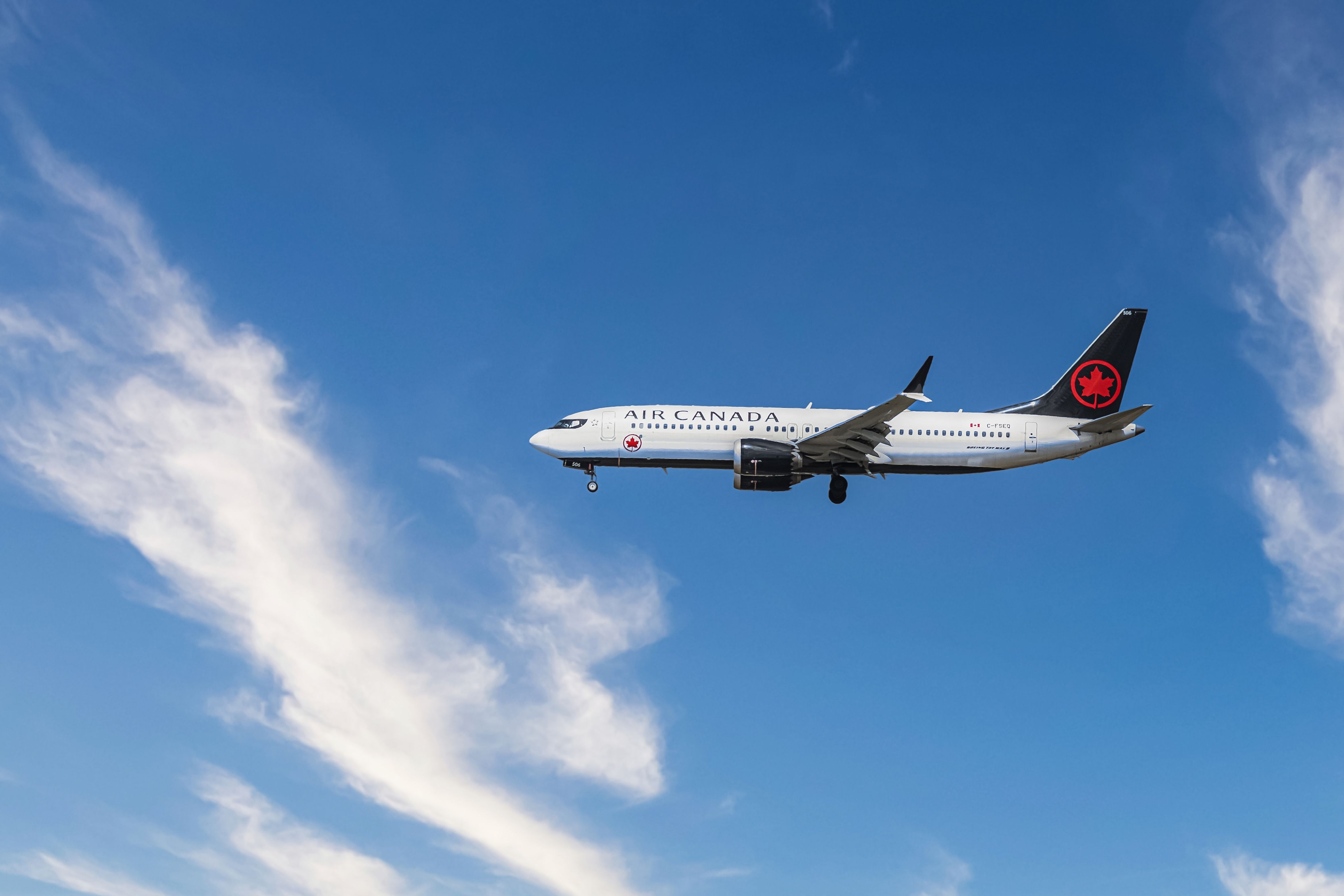 Air Canada flight in the sky during busy travel month.