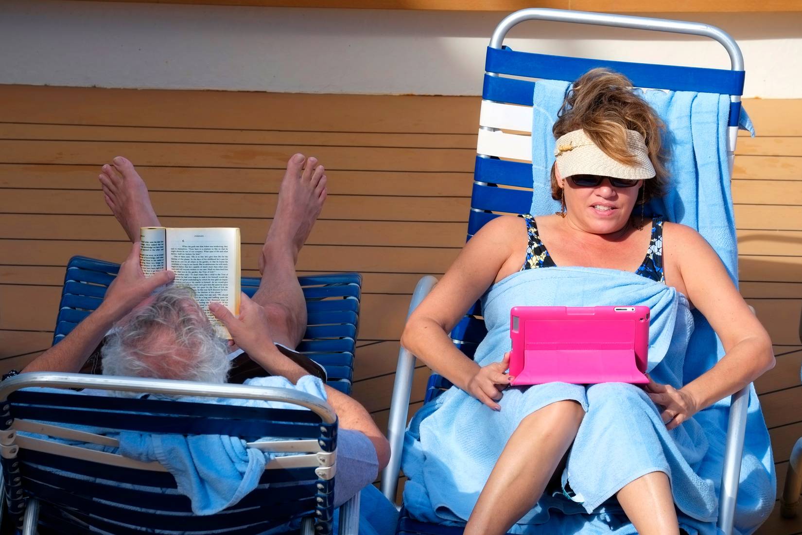Royal Caribbean passengers read books on the pool deck
