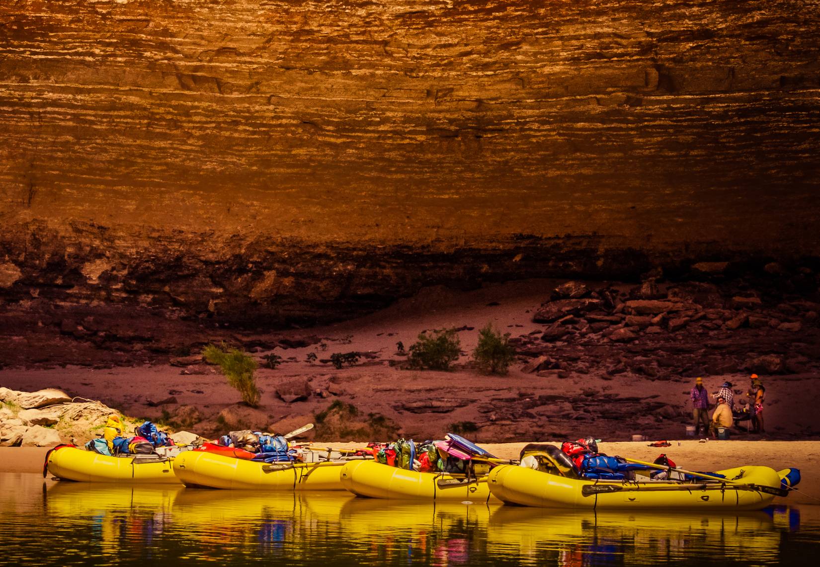 Bright yellow rafts tied up on the Colorado River in the Grand Canyon