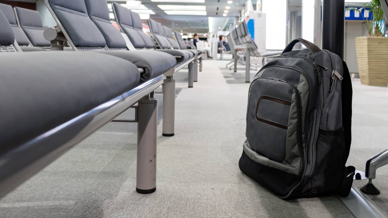 Unattended cabin backpack abandoned on the floor at the boarding waiting hall of an airport