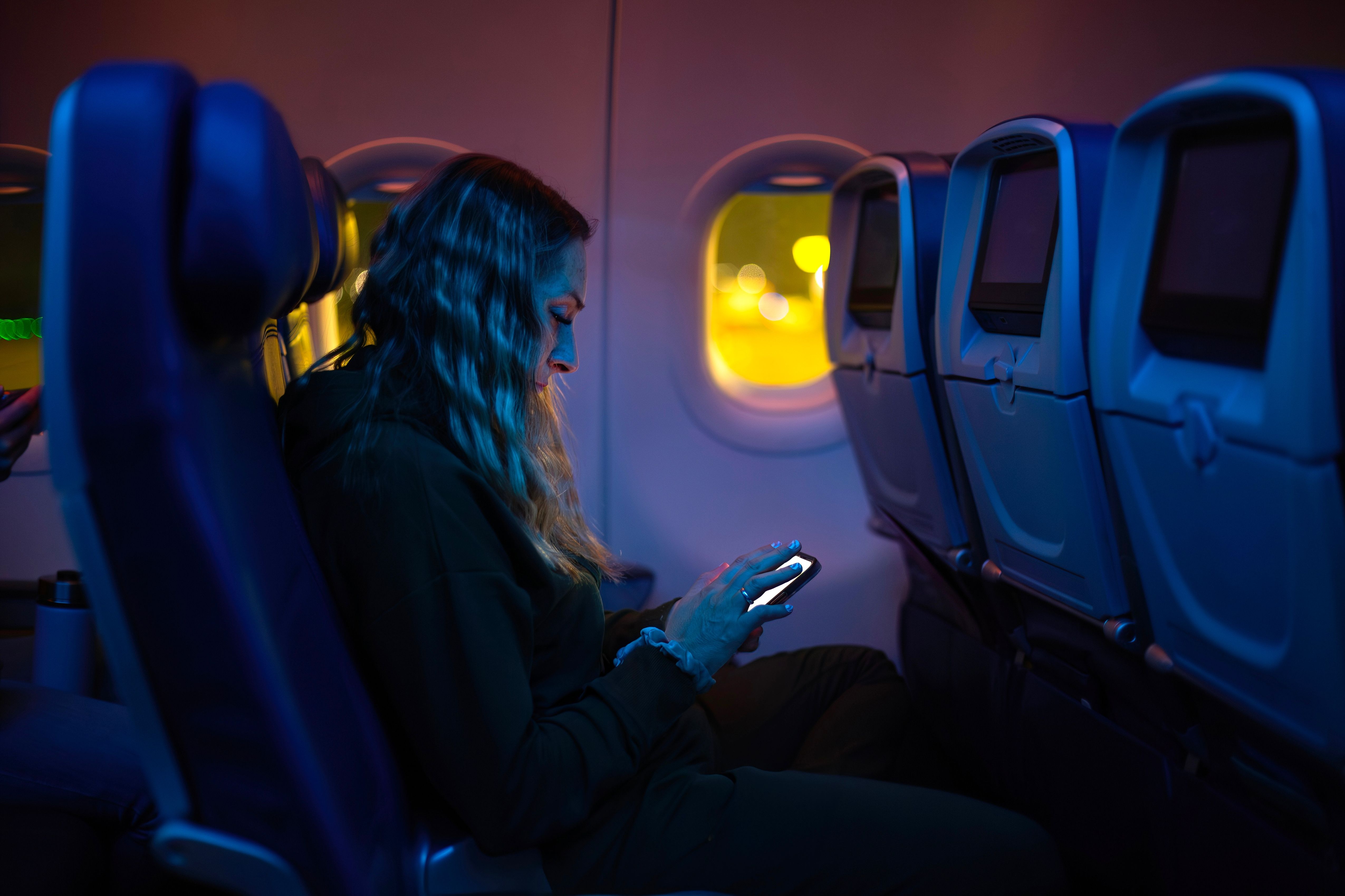 U.S. Influencer Shares Unbelievable Footage Of Passenger Using The Worst Possible Electronic Device On Night Flight
