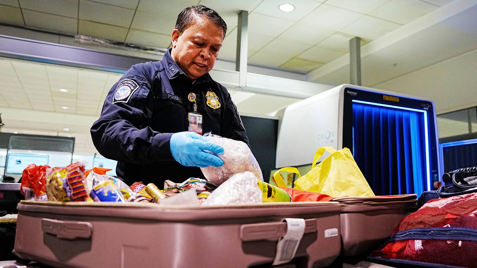 U.S. Customs and Border Protection officer inspecting luggage at a U.S. airport