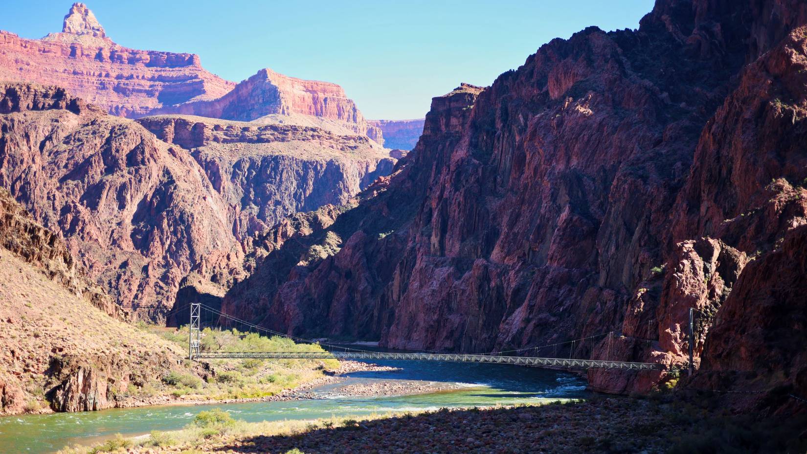 The Silver Bridge at the bottom of the Grand Canyon, which connects the Bright Angel Trail with the North Kaibab Trail, carries the Transcanyon Waterline suspended beneath its grated steel deck over the Colorado River 