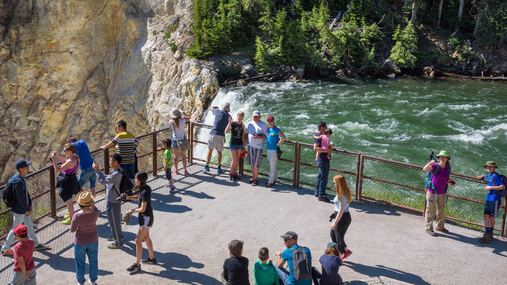 Tourists watching and taking pictures of the Lower Yellowstone Falls in Yellowstone National Park during the summer