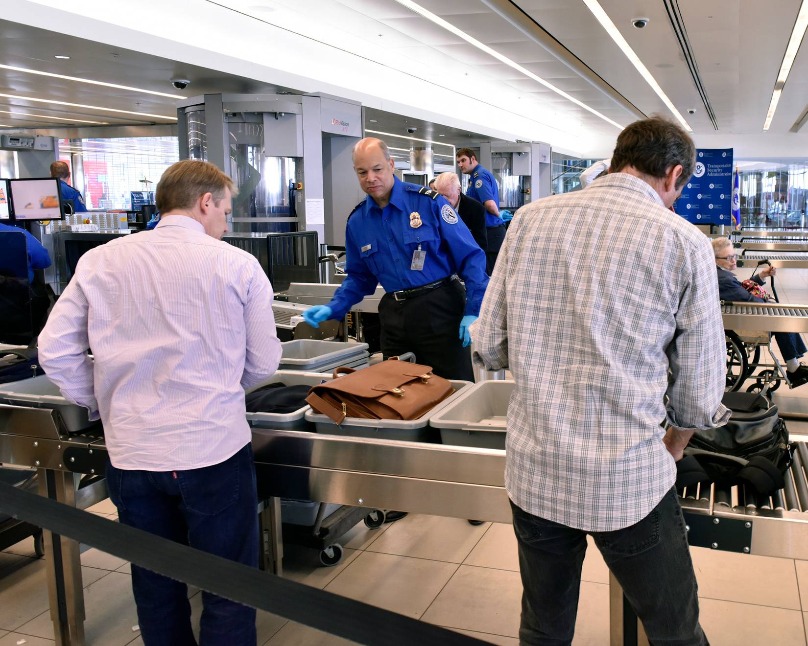 Transportation Security Administration (TSA) officer at a U.S. airport checking passenger bags