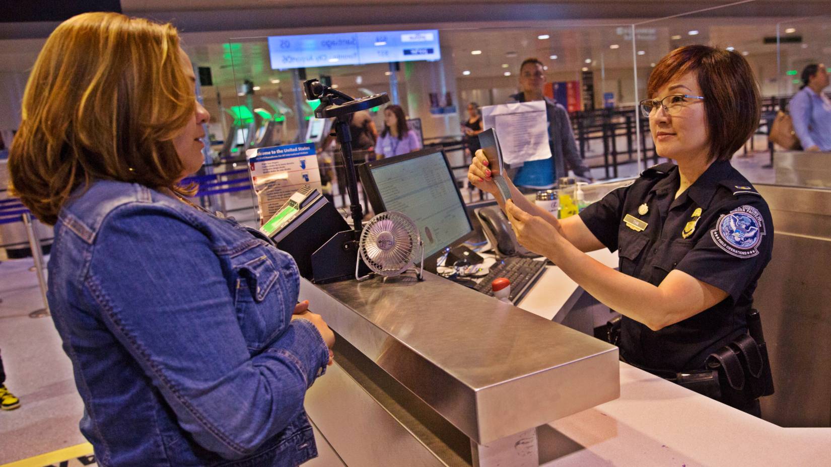 U.S. Customs and Border Protection officer processing an international traveler's passport at an airport