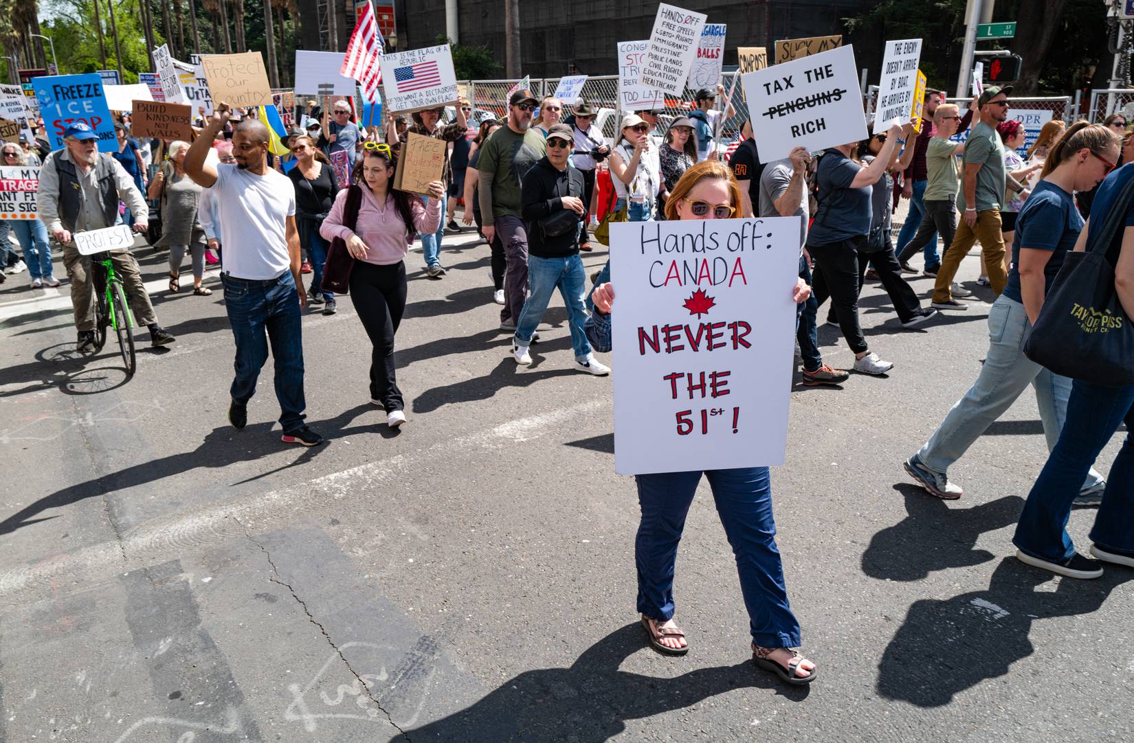 A woman with a "Hands Off Canada Never the 51st" sign marches on L Street at the conclusion of the 50501 Hands-Off protest