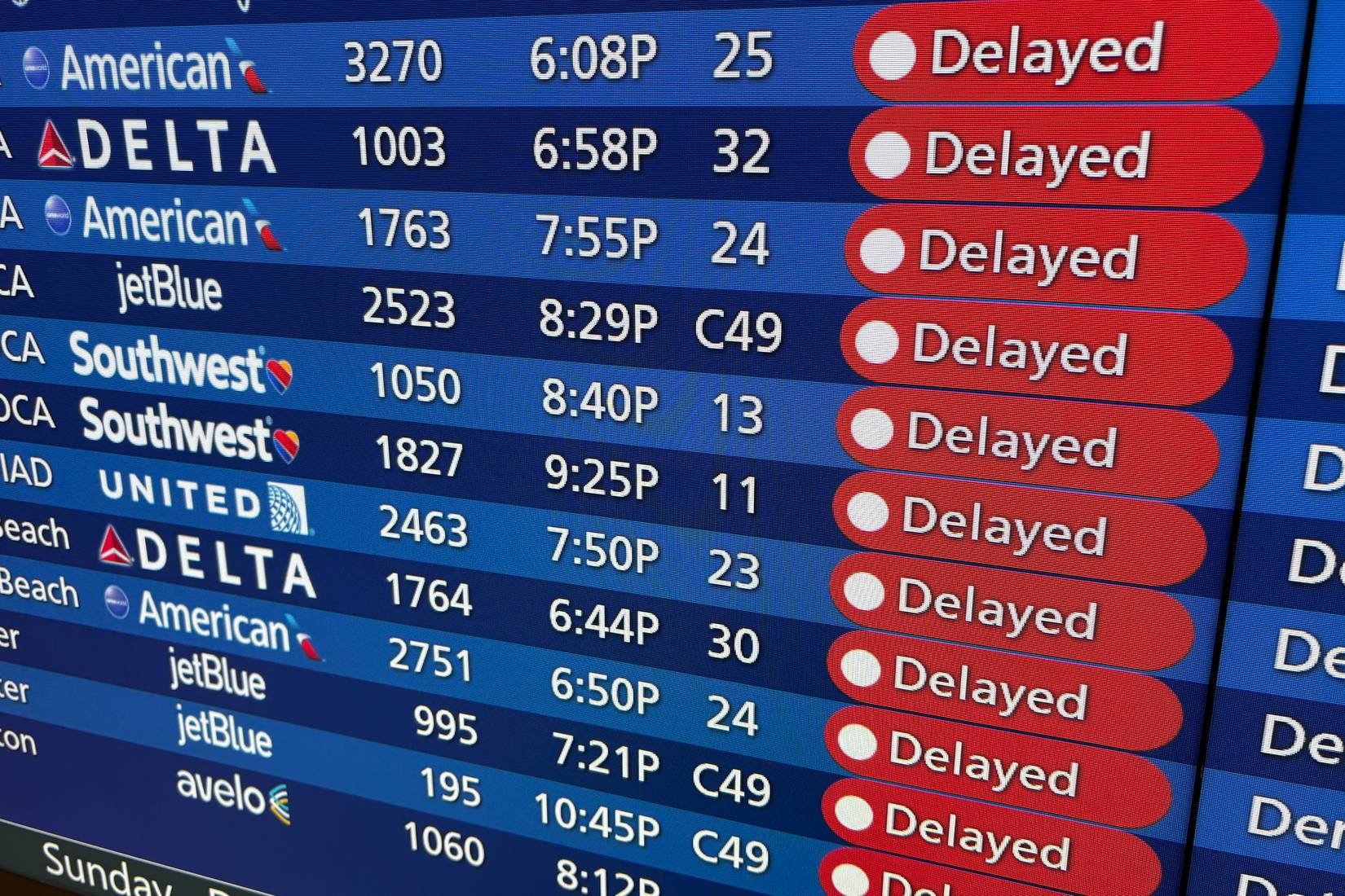 A video display board showing delayed flights