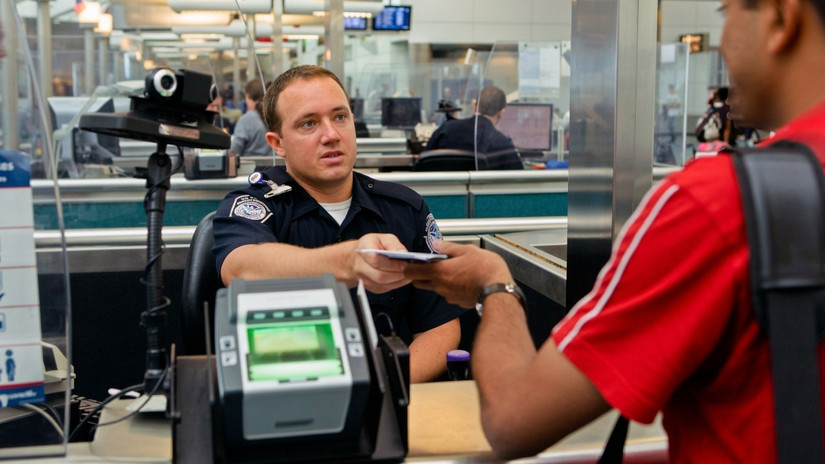 A U.S. Customs and Border Protection (CBP) officer processing an incoming passenger at Newark Liberty International Airport