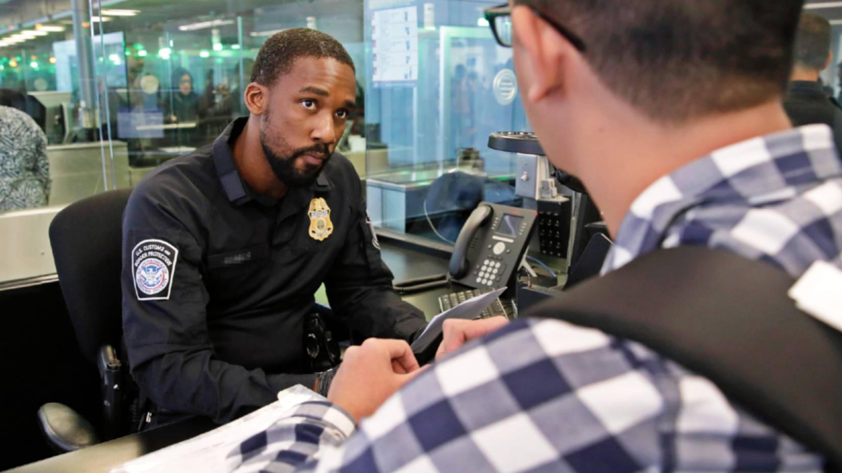 A U.S. Customs and Border Protection (CBP) officer processing an arriving international passenger at Philadelphia International Airport (PHL) in Philadelphia, Pennsylvania
